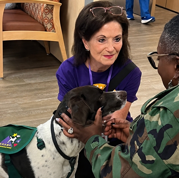 CHAMP Assistance Dogs facility dog greeting a visitor during a hospital outreach visit.