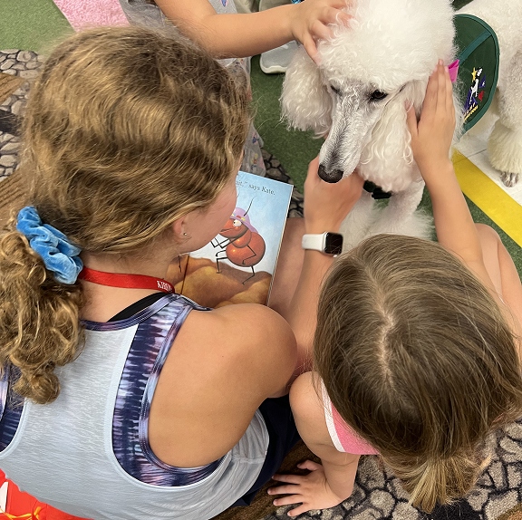 CHAMP Assistance Dogs facility poodle visiting a children's reading program.